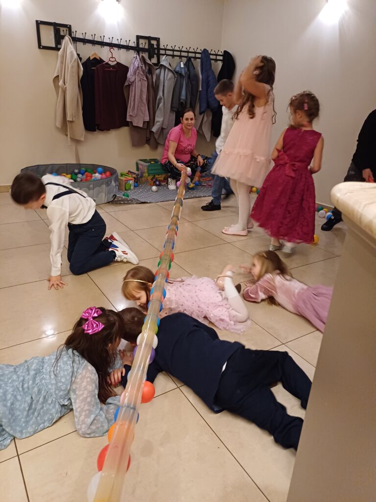 animacje na chrzciny komunię limbo dzieci przechodzą pod liną z piłeczek